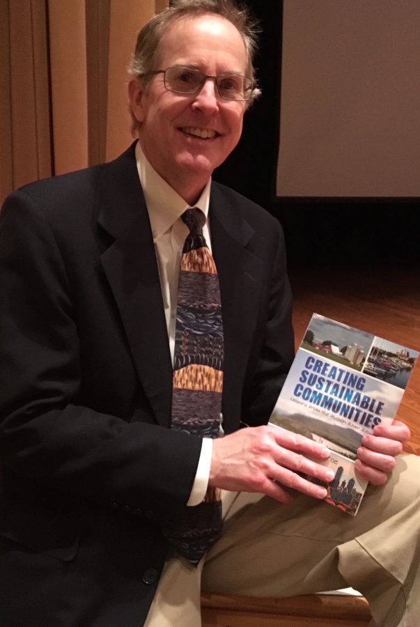 Author, environmentalist and professor Rik Scarce with his novel, Creating Sustainable Communities. 