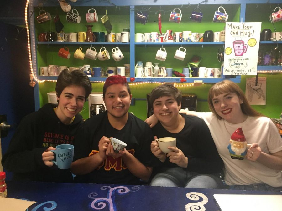 The picture features four people holding mugs with the background of shelves of different colored mugs set against a lime green painted wall.