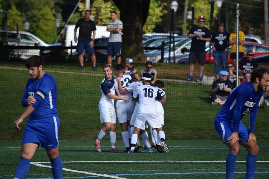 Members of the mens soccer team celebrate after a win. 