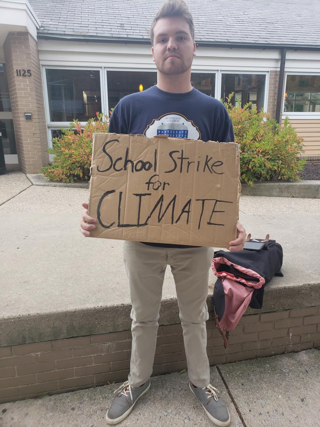 Brandon Faust, the leader of this strike on campus, holding a sign to protest climate change.