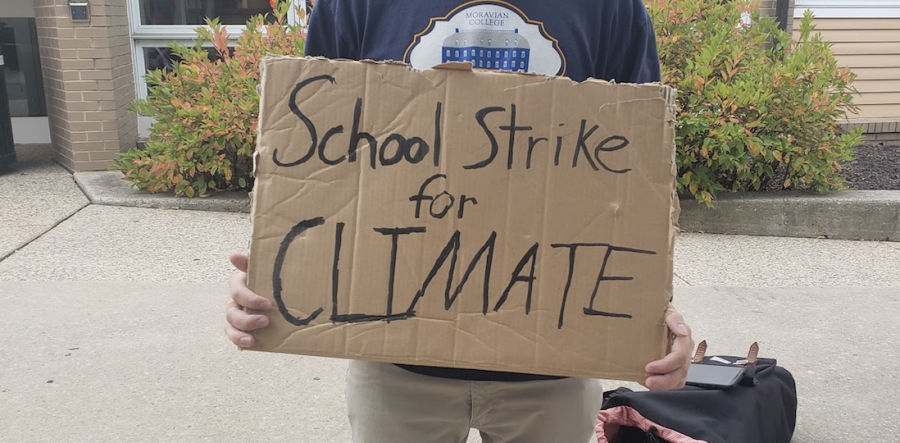 Brandon Faust, the leader of this strike on campus, holding a sign to protest climate change.