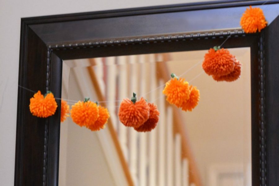 A string of pumpkins made from orange yarn.
