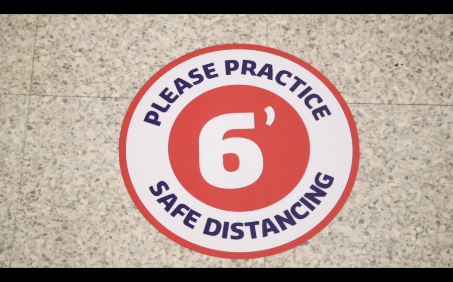 A still taken from President Grigsbys video address to students days before the semester began, showing the new stickers that encourage students to maintain a safe social distance while getting food in all dining locations; Photo Courtesy of: moravian.edu/fall-2020
