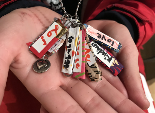 A student shows off her positivity charms that she created at the opening night of Loving Kindness: A Children’s and Teens’ Art Exhibition about Mindfulness on Jan. 27. Photo courtesy of Giavanna Murgia