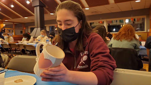 Avery Saldino paints a mug with a heart-shaped design in the HUB during Pottery Night. Photo courtesy of Dominic Trabosci