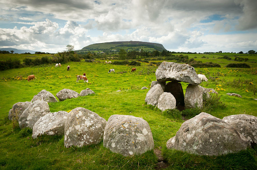 (a photograph of “The Kissing Stone” Dolmen and Stone Circle, in Carrowmore Megalithic Cemetery, by Bob Golden, from fineartamerica.com)