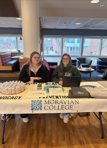 Public Health Club’s Vice President, Madeline Bill, and Social Media Chair, Kat Flores, advertise their club at USG’s Club Fair. 